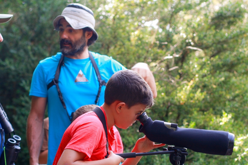 Teenager looking through a telescope on a Birdwatching Pyrenees experience